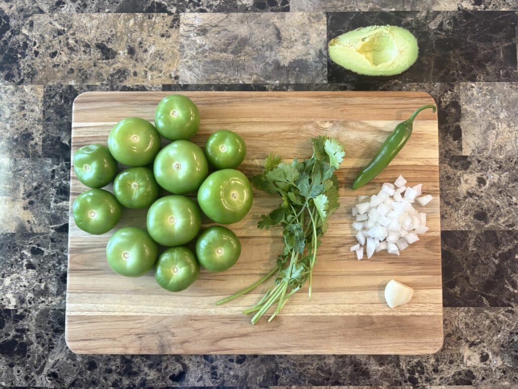 Avocado salsa verde ingredients on a cutting board.
