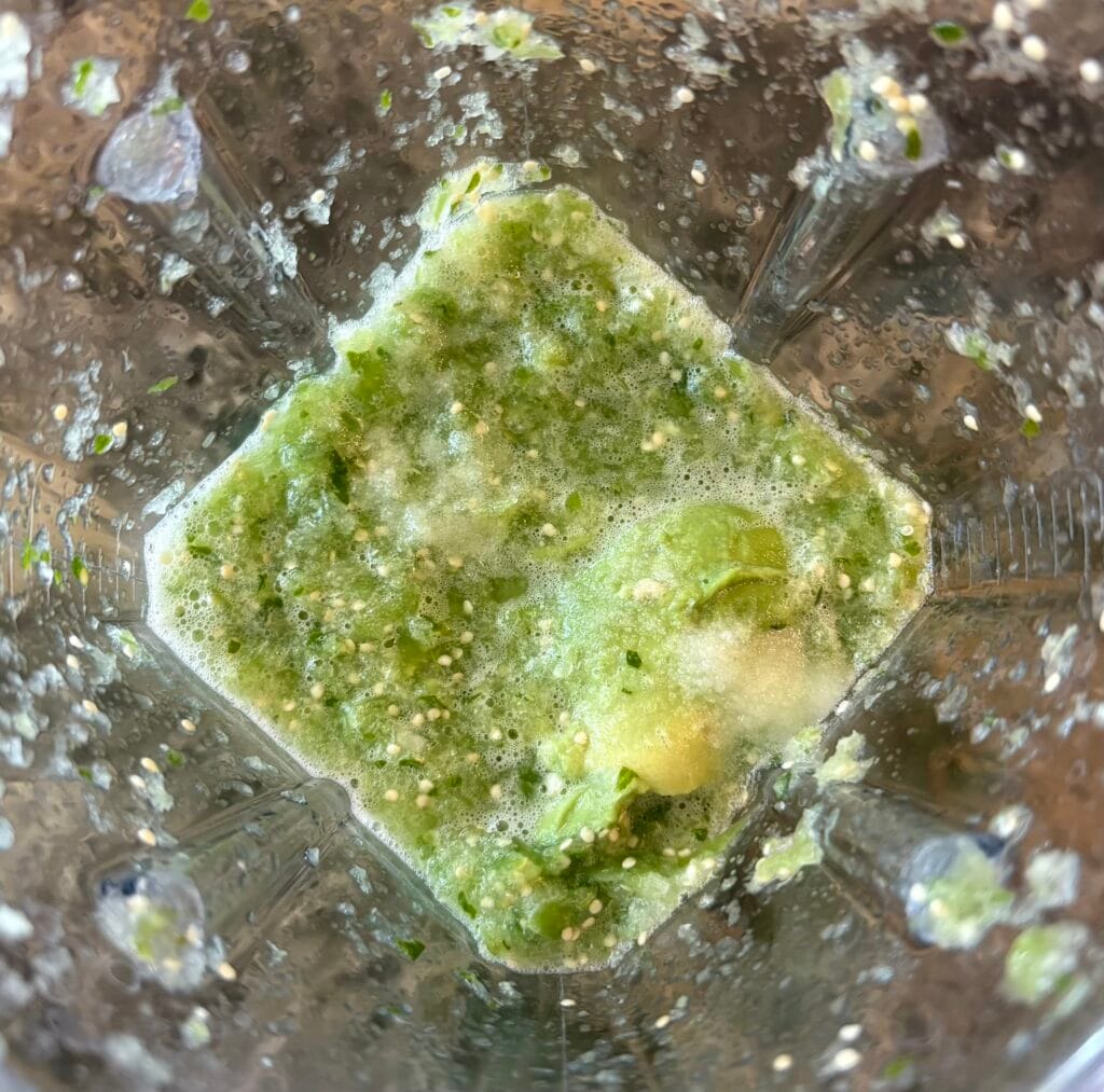 Avocado salsa verde in blender with avocado added.