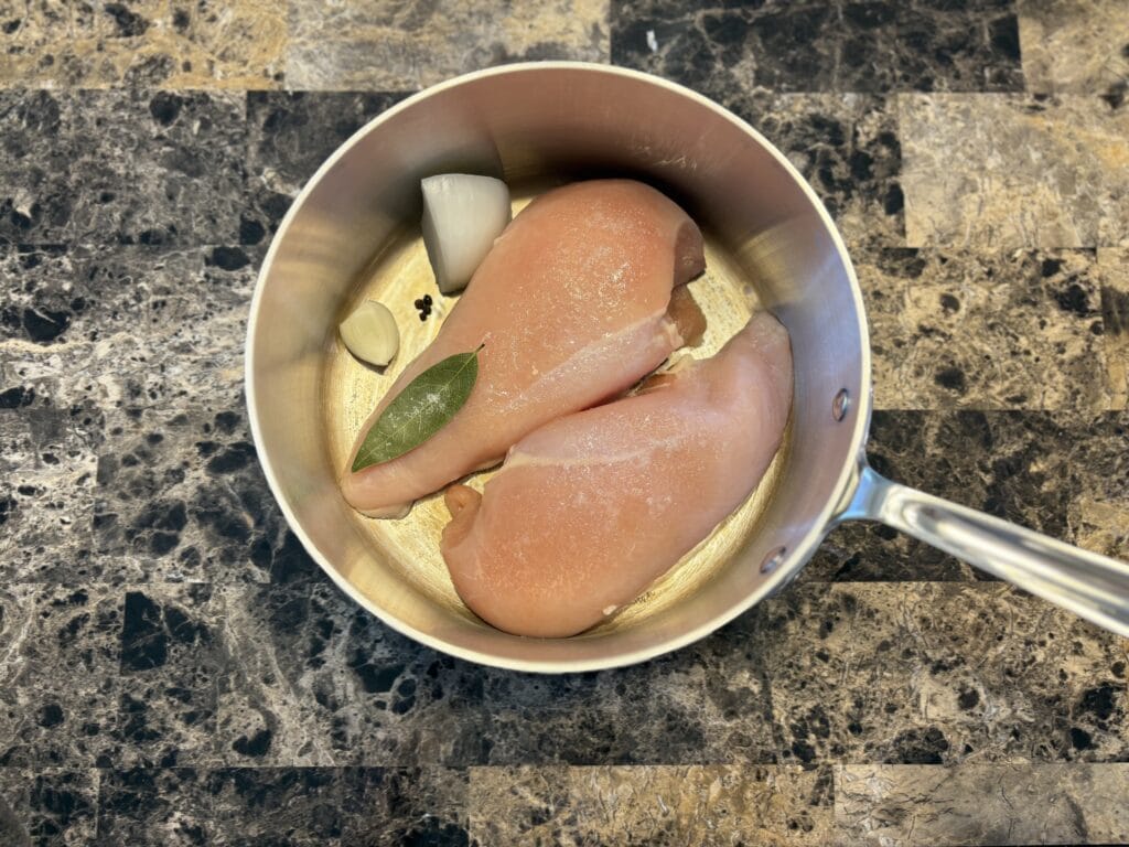 Top view of chicken tinga ingredients in a pot before cooking.