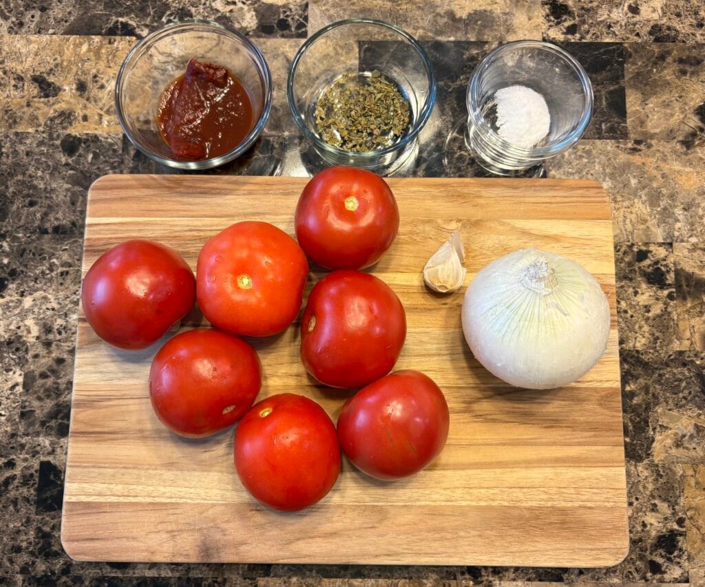 Top view of chicken tinga sauce ingredients on a table.