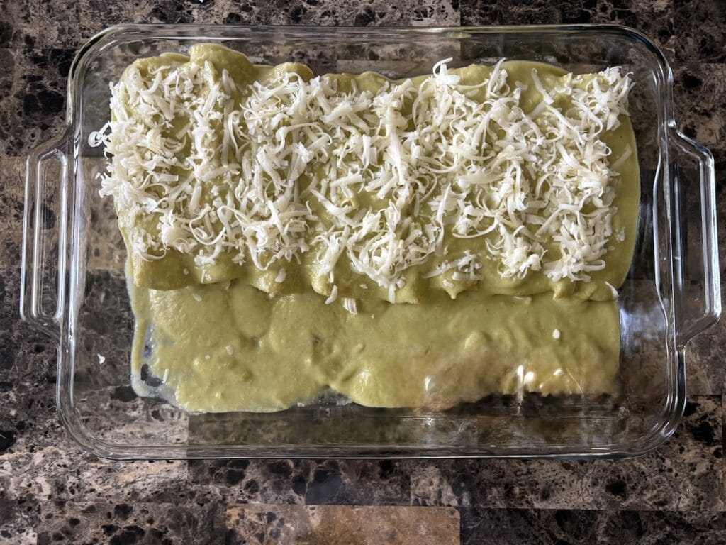 Top view of enchiladas suizas in baking dish before they are baked.