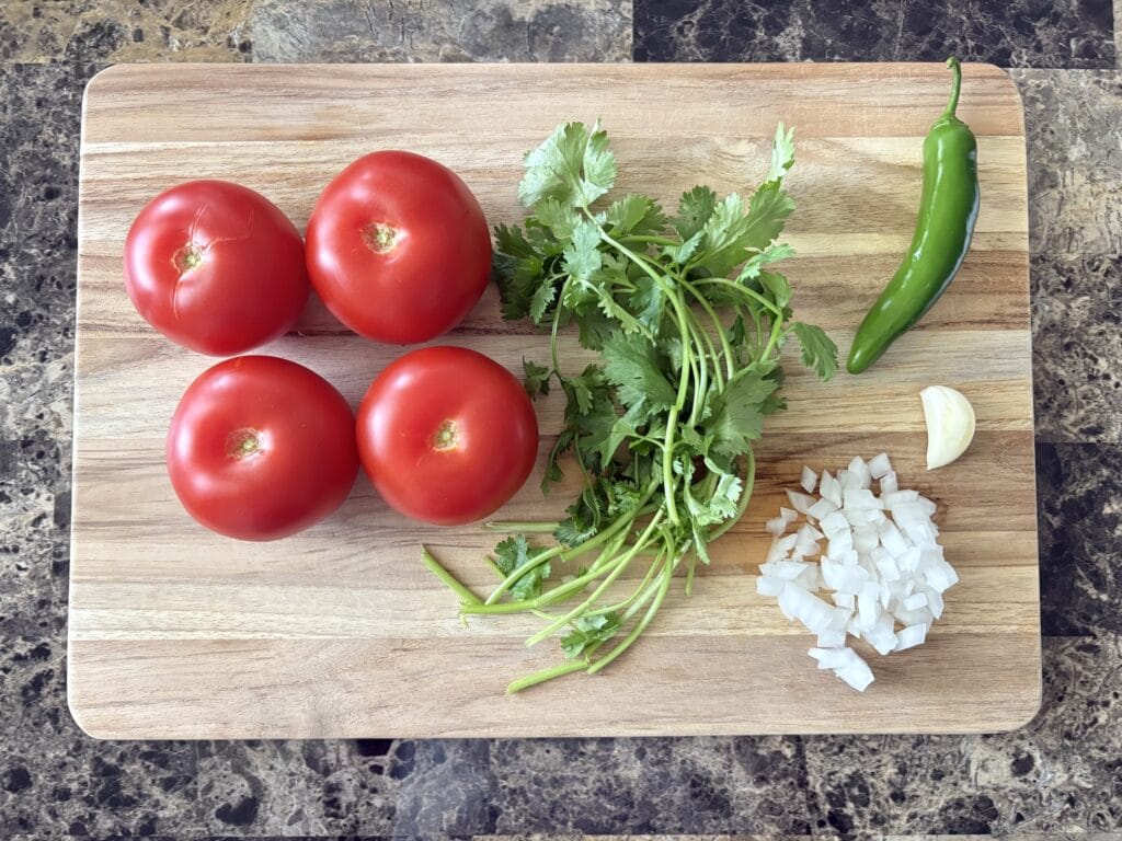 Salsa roja ingredients on a cutting board.