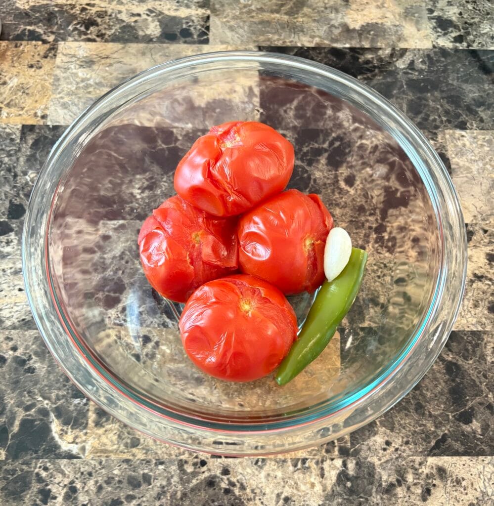 Salsa roja ingredients in a glass bowl after they were simmered.