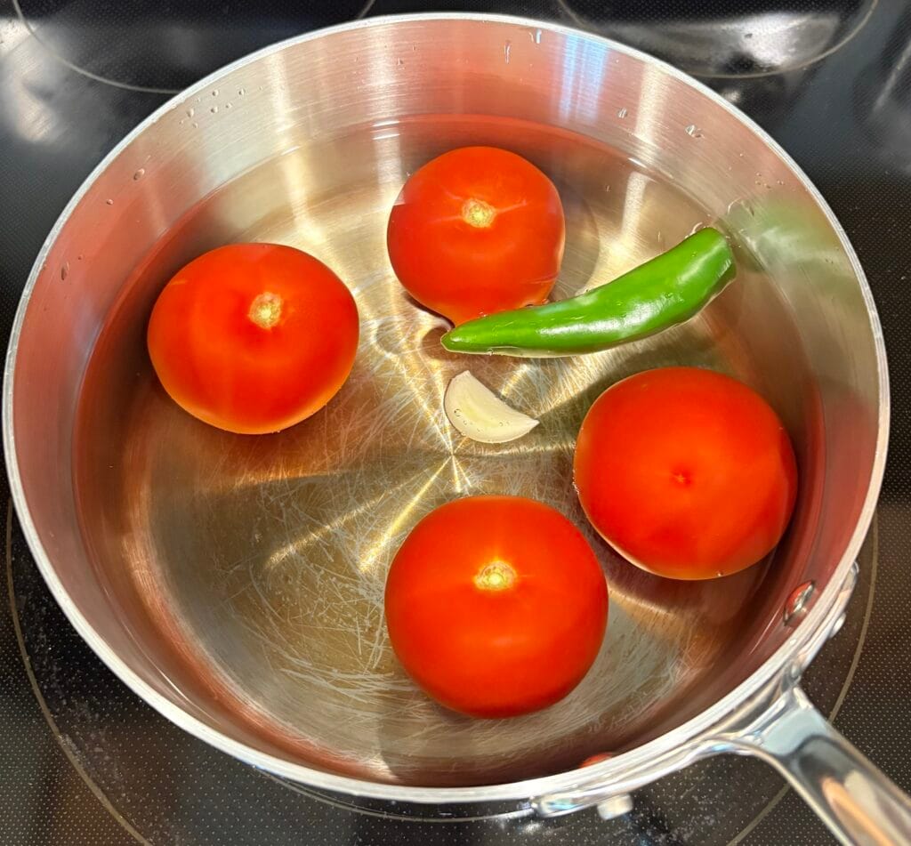 Salsa roja ingredients in a pot with water ready to simmer.