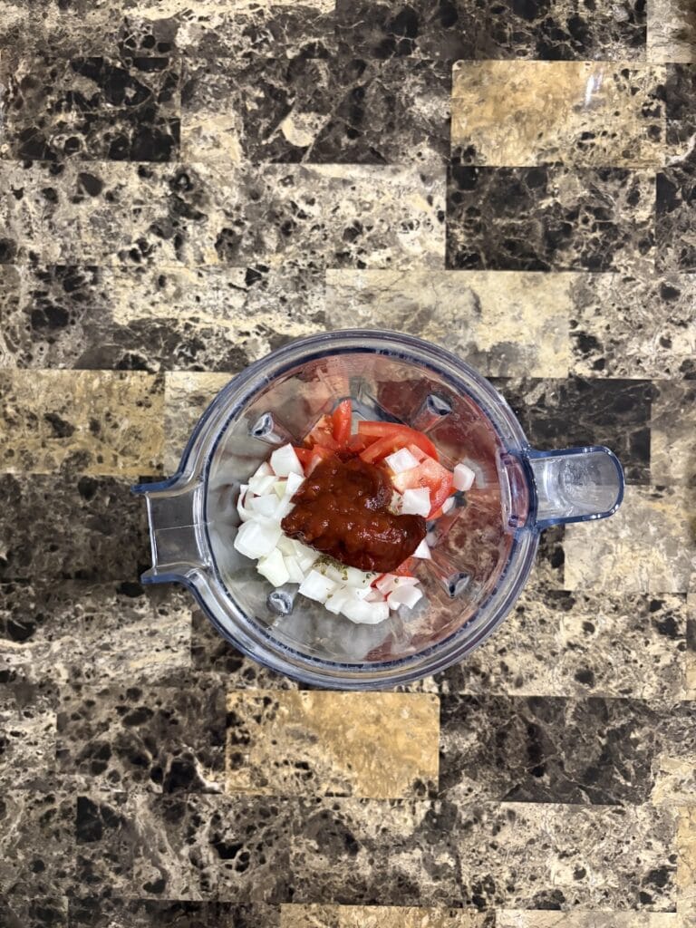 Top view of chipotle meatball sauce ingredients in a blender.