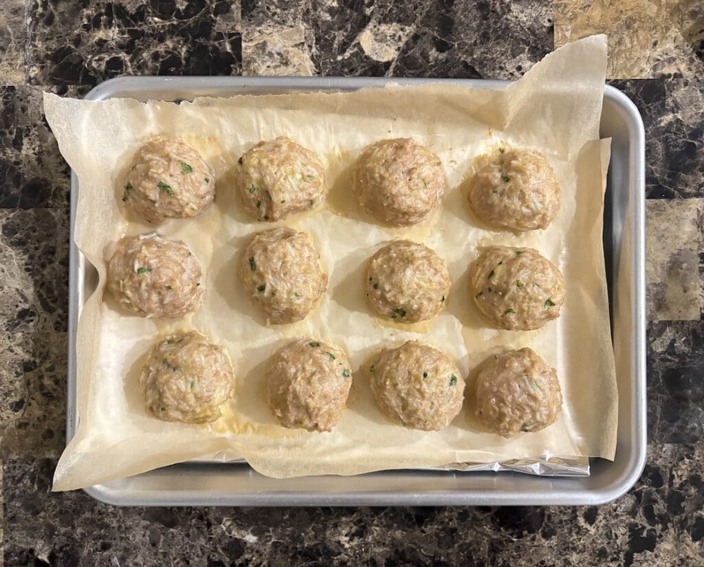 Top view of cooked chipotle meatballs on a baking sheet.