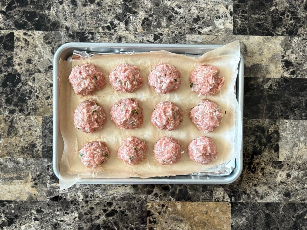 Top view of raw chipotle meatballs on a baking sheet.