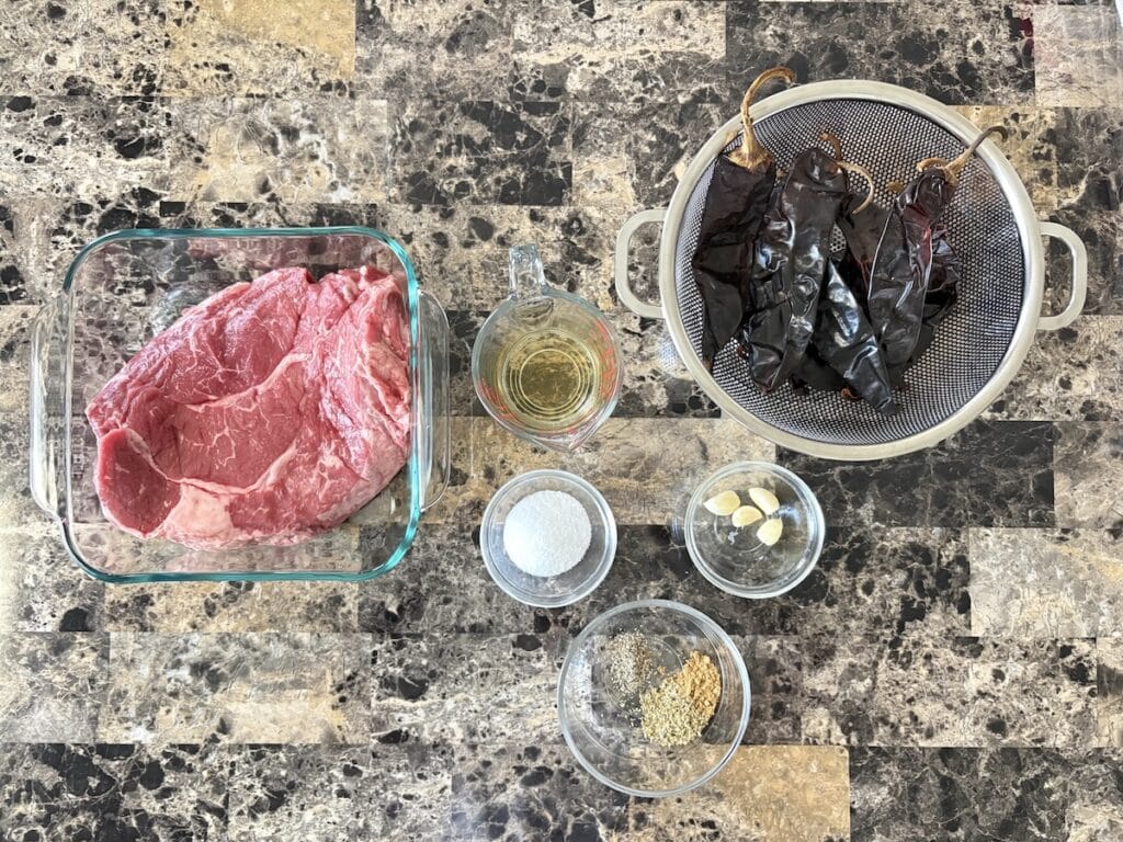 Top view of beef birria ingredients on a table.